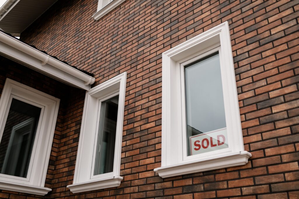brick house with a sold sign in the window