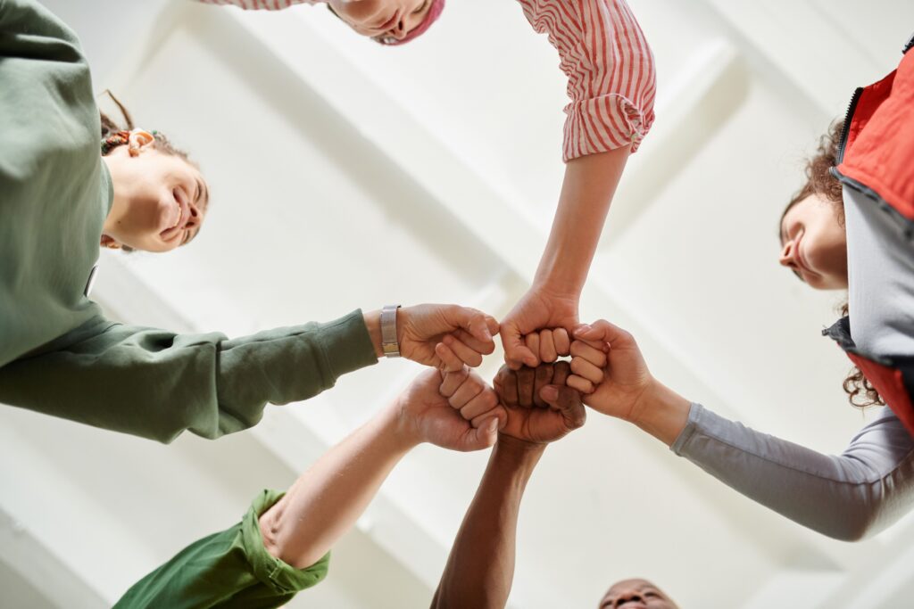 team members join fists together displaying unity